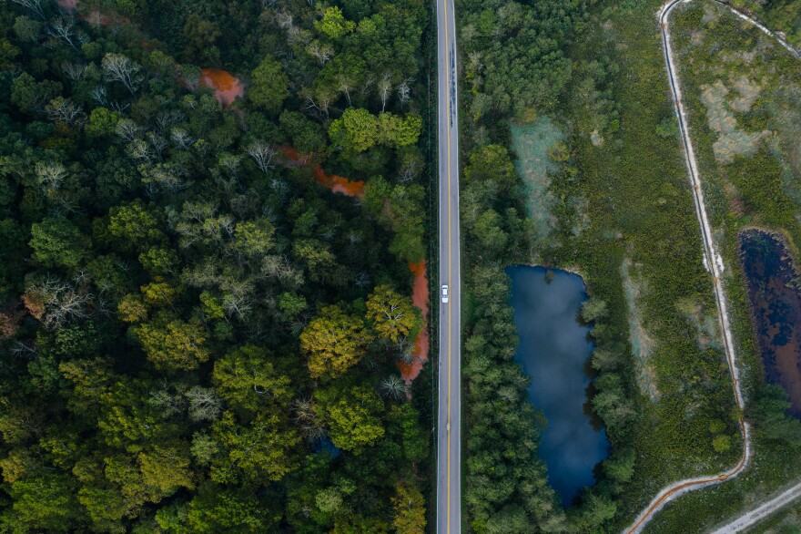 A creek (left) contaminated with acid mine drainage flows past a local rural road while the Carbondale doser (right) works to neutralize some of the acidity before it reaches local streams.