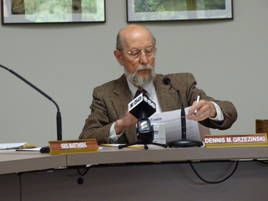 Chair Dennis Grzezinski takes his turn signing the ad hoc committee recommendation to select Jacobs