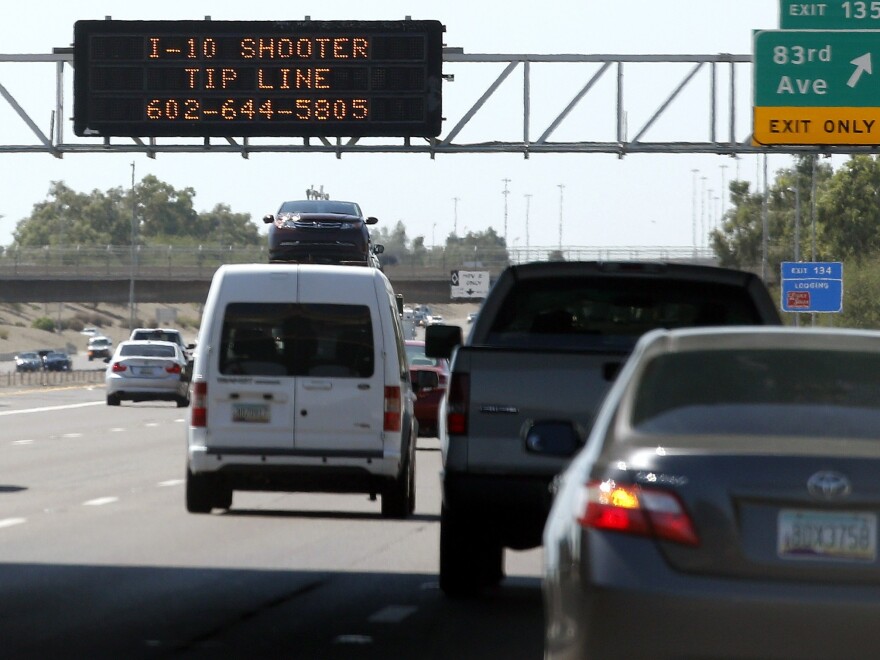 A sign displays a shooter tip line above Interstate 10 on Sept. 11 in Phoenix. Authorities have arrested a suspect in a string of freeway shootings over the past two weeks.