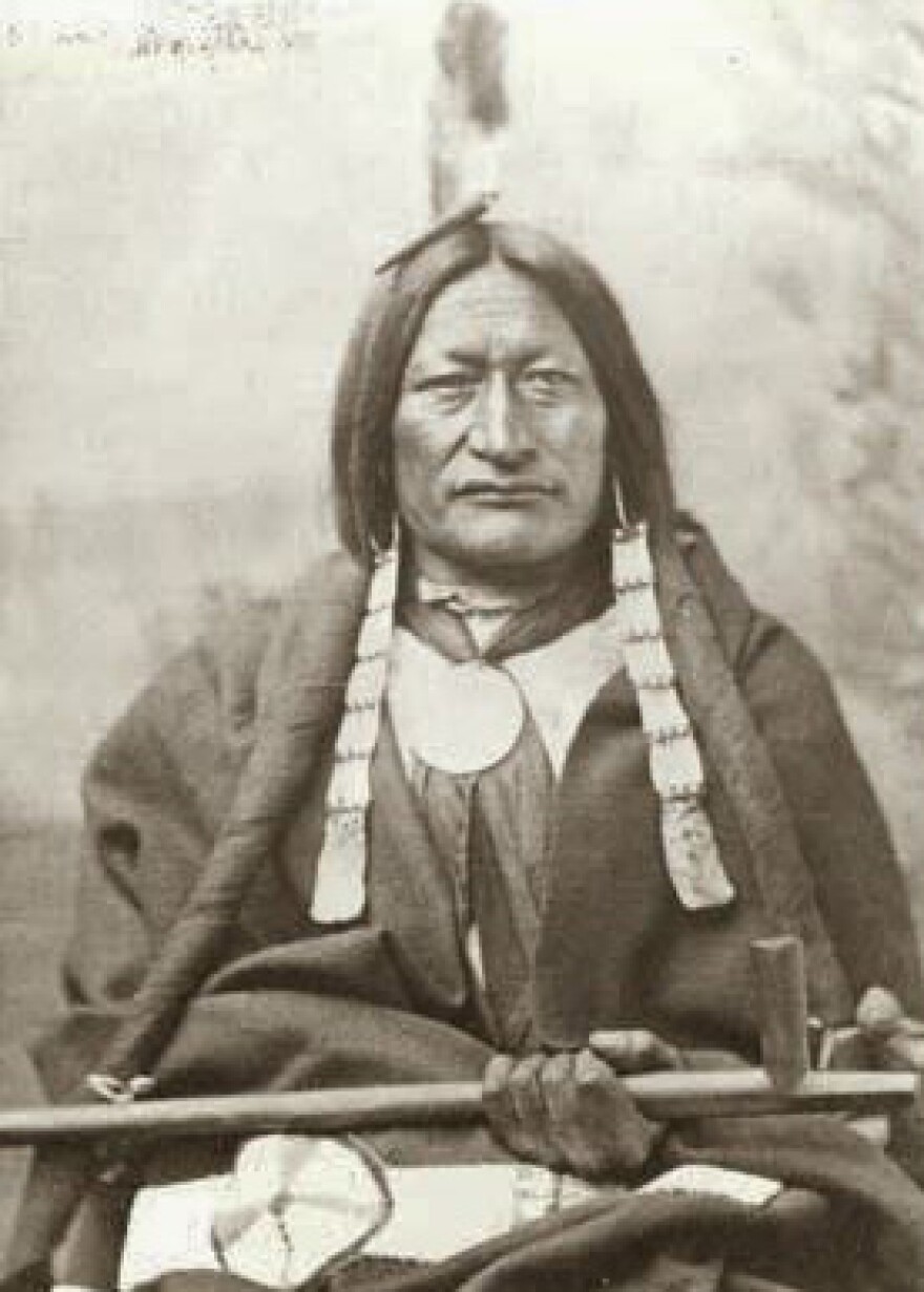 An image of native American Chief Little Wolf of the Northern Cheyenne Band. He is sitting, has a feather in his hair and a clay and wooden pipe on his lap