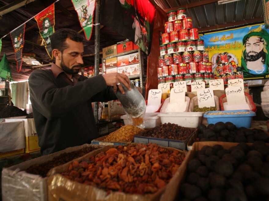 An Iraqi shop owner sells groceries in Baghdad. World Bank President Robert Zoellick says the high cost of food is an "aggravating factor" behind the unrest in the Middle East.