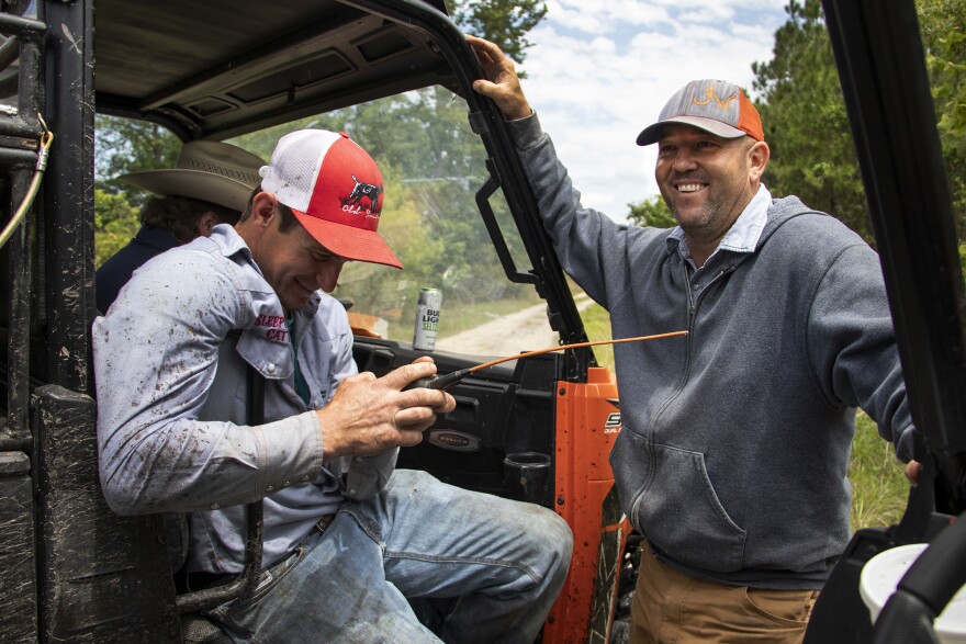 Wesley Markham talks with a friend while he tracks his cur dogs during a hog hunt at Otter Creek Ranch, near Chiefland, Fla. (Lauren Witte/WUFT News)