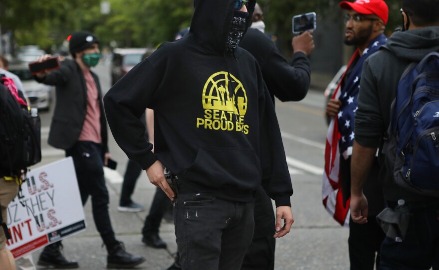 Members of the far-right group Proud Boys hold firearms as they disrupt a gathering in the occupied zone in Seattle on Monday.