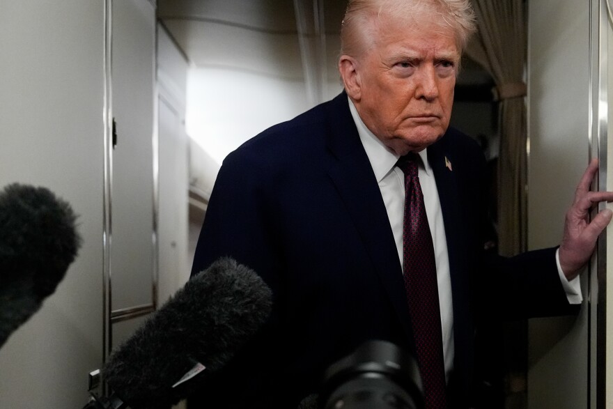President Donald Trump speaks to reporters while in flight on Air Force One to Joint Base Andrews, Md., Sunday, Jan. 11, 2026.