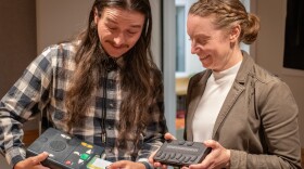 Jason Powers, audio recording manager, and Cara Rothman, state librarian, hold an audio player and braille e-reader, April 23, 2026