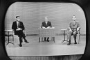FILE - In this Sept. 26, 1960 file photo, moderator Howard K. Smith sits between, Sen. John Kennedy, left, and Vice President Richard Nixon as they appear on television studio monitor set during their debate in Chicago. (AP Photo)