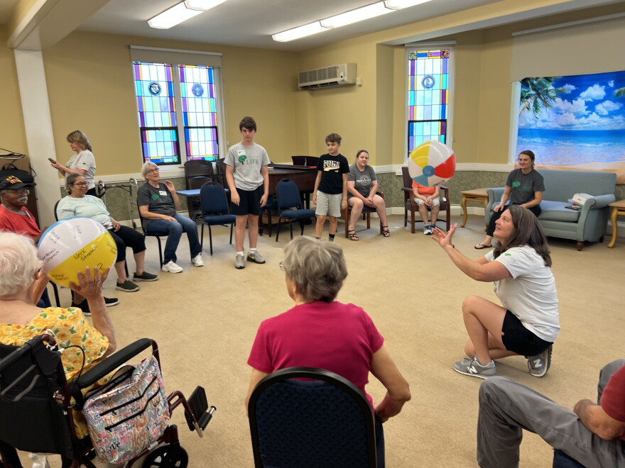Wooster memory cafe participants pass around a beach ball to match the week's beach theme.