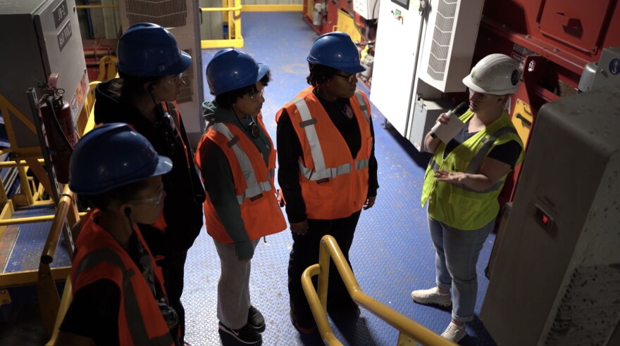 Her Voice Media fellows tour the Scott Area Recycling Center alongside Rachel Evans (right), communications coordinator for the Waste Commission of Scott County.