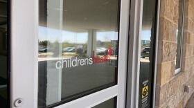 The logo for Children's Health hopsital system is on a screen door and the logo is adorned with a red balloon.