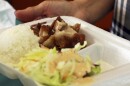 FILE - In this 2019 photo, a restaurant worker in Honolulu holds a polystyrene foam box containing an order of roast pork, rice and salad.
