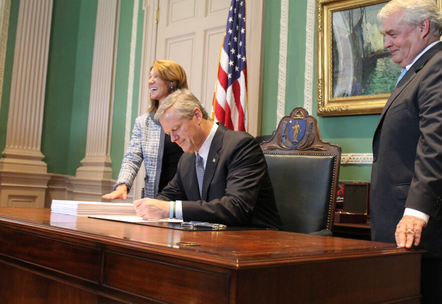 Massachusetts Governor Charlie Baker signs the fiscal 2019 budget in his office alongside Lt. Gov. Karyn Polito and Administration and Finance Secretary Mike Heffernan.