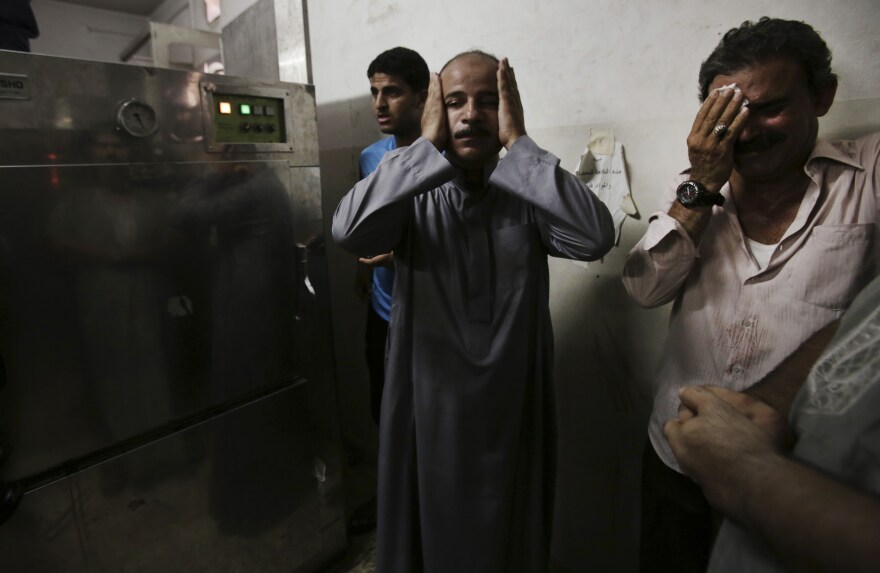 In the morgue of Gaza's Shifa hospital, Palestinian relatives mourn following an explosion that reportedly killed at least 10 people Monday, nine of them said to be children.