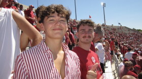 Two students pose for picture at IU football game. 