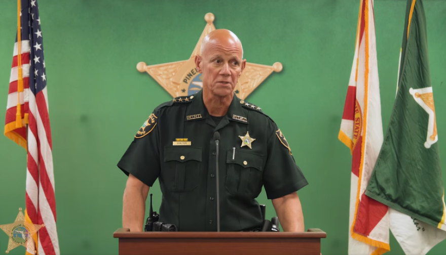 Man speaking into microphone at a podium