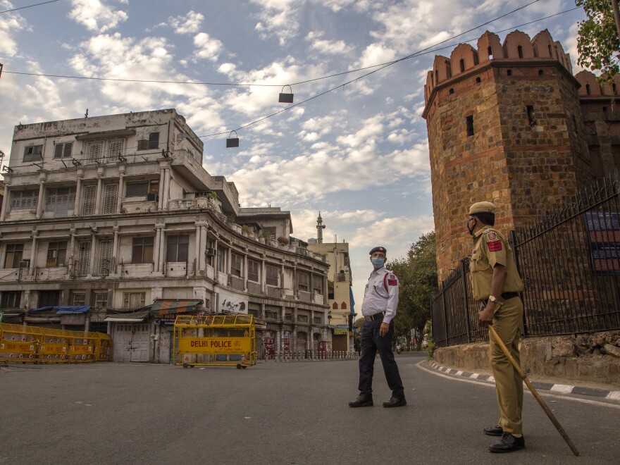 Indian policemen stand guard on a deserted road in New Delhi as India remains under lockdown over the coronavirus.