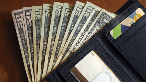 FILE - In this June 15, 2018, file photo, cash is fanned out from a wallet.