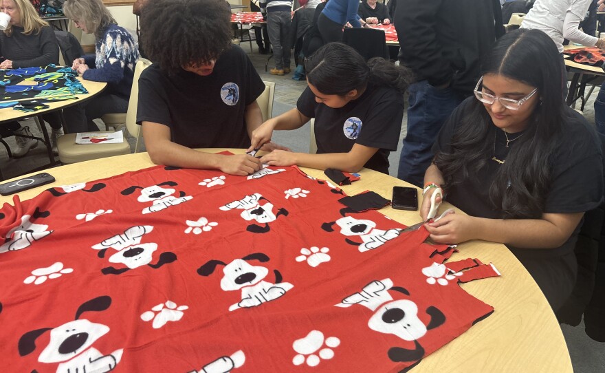 Wilkes-Barre Area High robotics club students Kaike Gonzales, 12th grade, Isabella DeGraffenreid 10th grade and Inaaya Qaiser, 8th grade make fringe blankets on MLK Day on Jan. 20 for Blankets & Broth.