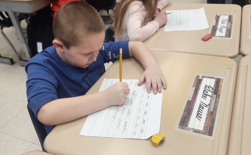Second-grade student Blake Nause works on his cursive handwriting.