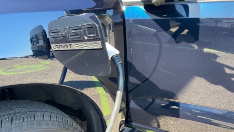 A charging cord plugs into the electric Ford F-150 Lightning