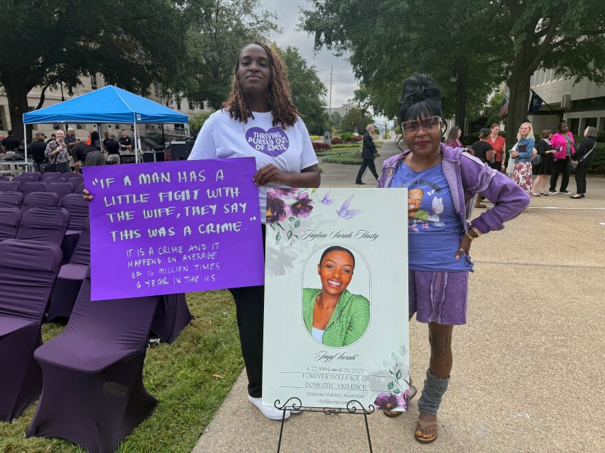 Monica Hatton (right) stands by a sign commemorating Jaylan Hasty. "Someone said to me 'you may want to stop counting the days [since Hasty died],'" Hatton said. "That is my way of keeping the story real."
