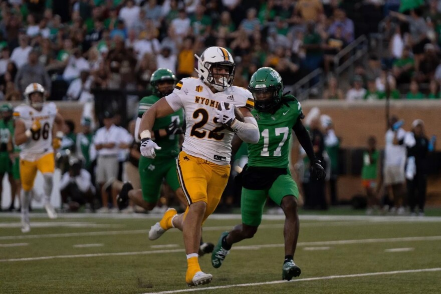 Running back Sam Scott escapes University of North Texas defenders en route to a 41 yard touchdown. 
