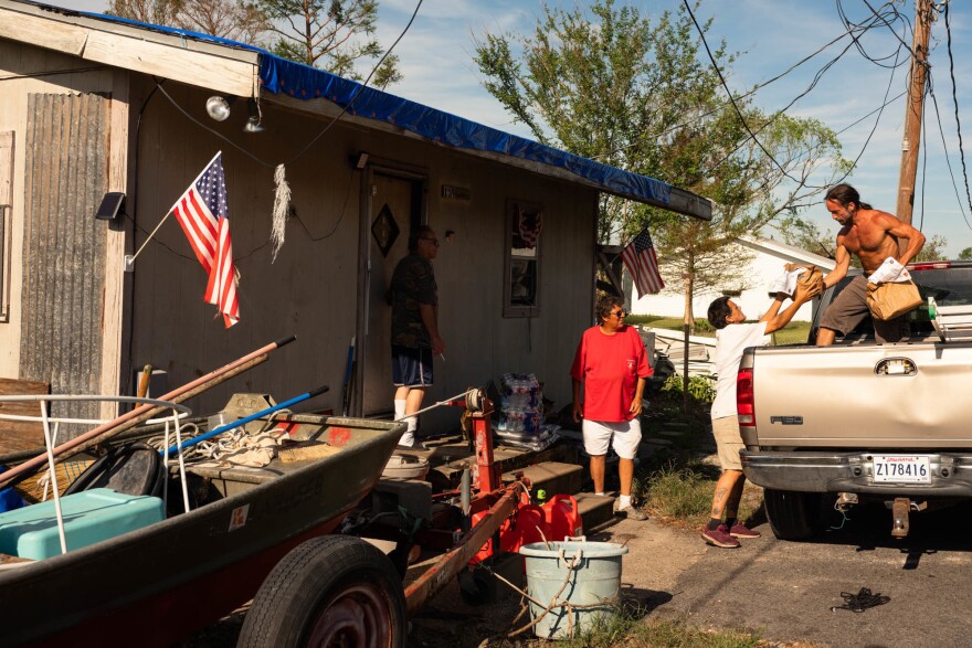 Jordan Menard, of <a href="https://www.bvlbanchacollective.com/">Bvlbancha Collective</a>, helps tribal elders on Sept. 22, in the wake of Hurricane Ida.