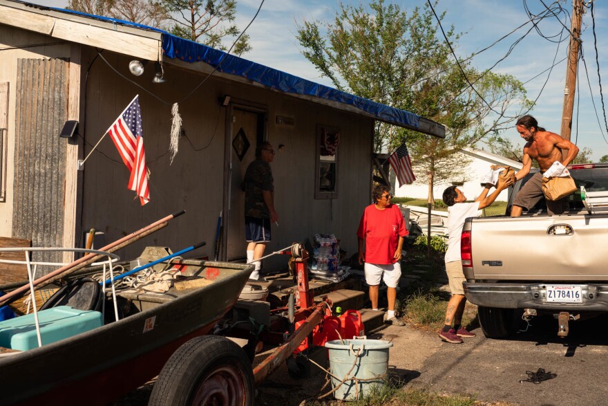 Jordan Menard, of <a href="https://www.bvlbanchacollective.com/">Bvlbancha Collective</a>, helps tribal elders on Sept. 22, in the wake of Hurricane Ida.