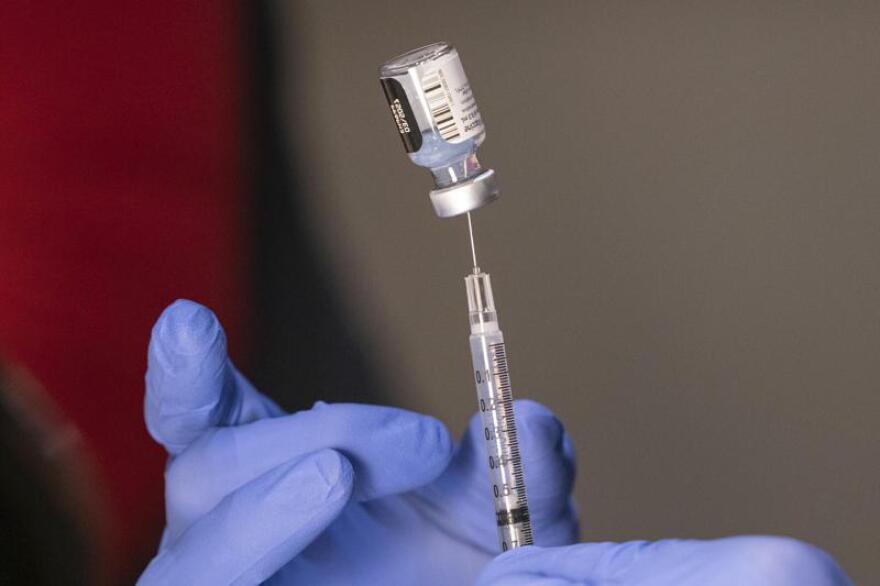 Pharmacist Ron Simono fills a syringe with a dose of the Pfizer-BioNtech COVID-19 vaccine during a vaccine clinic on Dec. 16, 2020, at Providence Alaska Medical Center in Anchorage, Alaska. Indian Health Service announced Thursday, Nov. 17, 2022, that all tribal members covered by the federal agency will be offered a vaccine at every appointment when appropriate under a new vaccine strategy. Throughout the pandemic, American Indians and Alaska Natives have had some of the highest COVID-19 vaccination rates across the country.