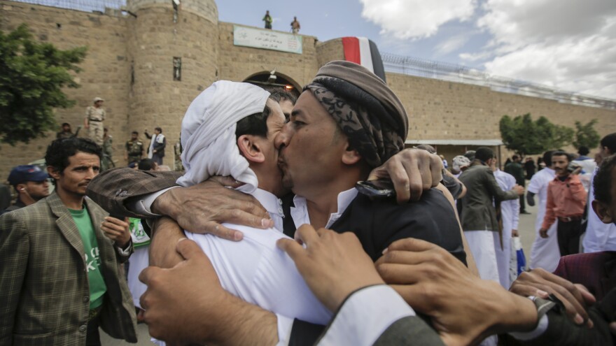 A Yemeni detainee (left) is greeted by a family member after being released by Houthi rebels on Monday. The release was brokered by the International Committee of the Red Cross.