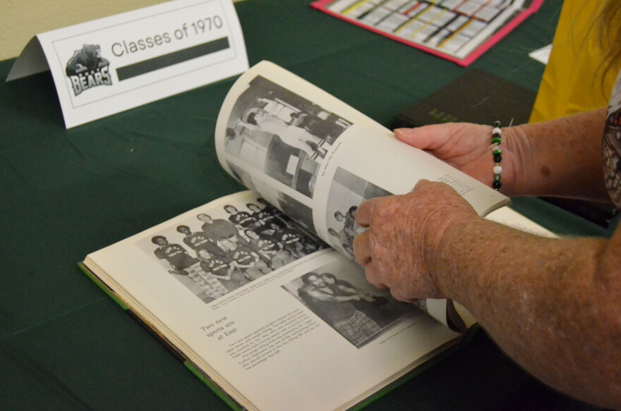 East High School alumni flip through decades-old yearbooks as they celebrate its 100th anniversary.