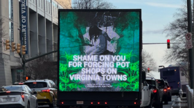 A truck featuring pictures of Democratic elected officials and the message "shame on you for forcing pot shops on Virginia towns," drives passed the Virginia General Assembly building in Richmond. 