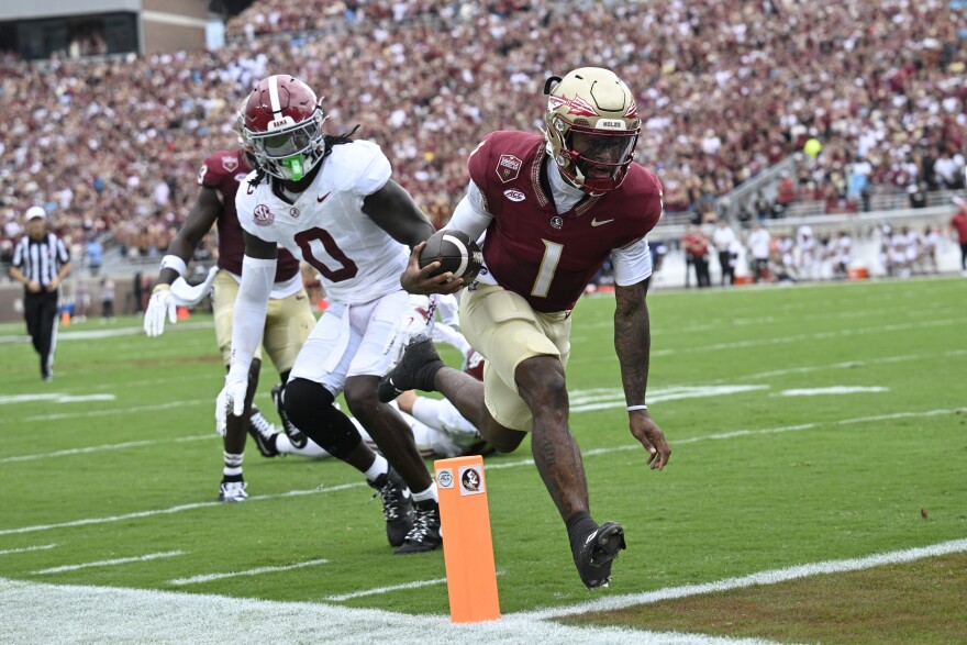 Florida State quarterback Tommy Castellanos (1) scores a 9-yard rushing touchdown past Alabama linebacker Deontae Lawson (0) during the first half of an NCAA college football game, Saturday, Aug. 30, 2025, in Tallahassee, Fla. (AP Photo/Phelan M. Ebenhack)