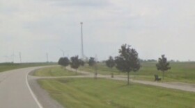 image of a hiking biking trail next to a rural road, with young trees along the side of the trail.