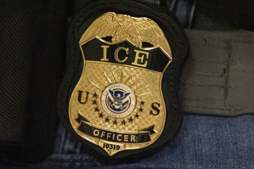 FILE - A federal agent wears an Immigration and Customs Enforcement badge in New York, June 10, 2025. 