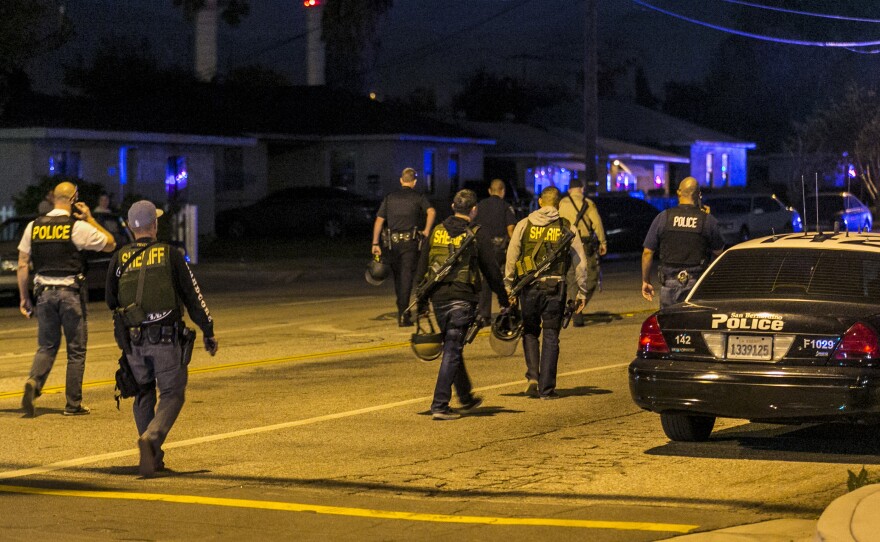 Authorities guard the perimeter near the location of the mass shooting in San Bernardino. Police Chief Jarrod Burguan said one man and one woman were killed when police chased the suspects' SUV and exchanged fire.