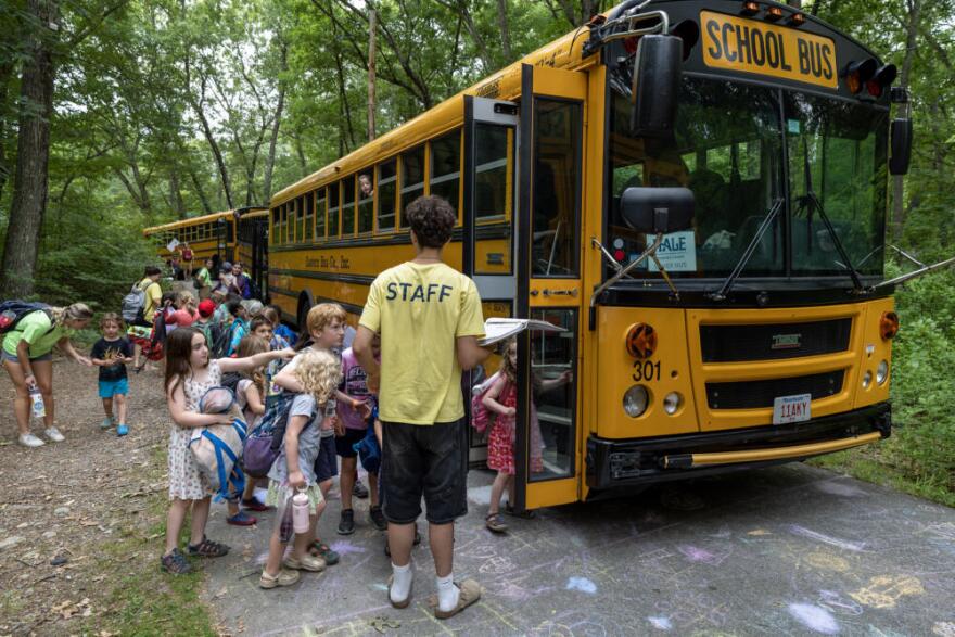 Hale Day Camp campers line up to climb aboard their buses for the drive home.  (Robin Lubbock/WBUR)