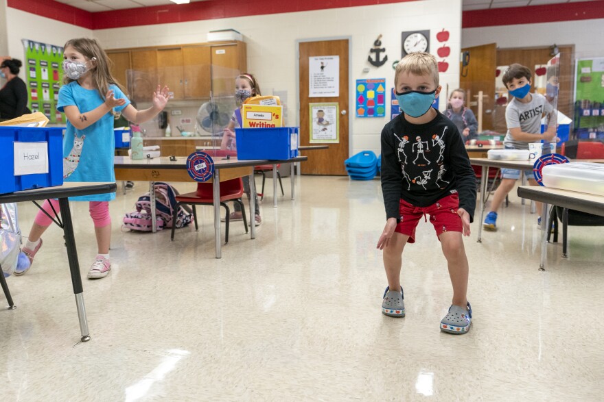 Kindergarten students wear face masks as they do a movement exercise at the Osborn School, Tuesday, Oct. 6, 2020, in Rye, N.Y. 