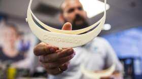 Limbitless co-founder Dominique Courbin display's a completed face shield part that was printed on a 3D printer at Limbitless. Photo: UCF