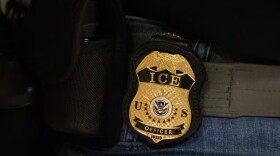 A federal agent wears a badge of Immigration and Customs Enforcement while standing outside an immigration courtroom at the Jacob K. Javits Federal Building in New York, Tuesday, June 10, 2025.