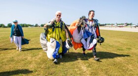 Don Watkins, 77, left, of Elk Rapids, and Matthew Heyl of Cleveland walk back to the Skydive Charlevoix hanger after Watkins presumingly broke the world record for oldest wingsuit skydiver.