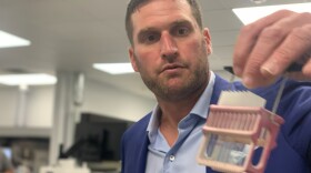 Dr. Aaron Rossi holds up a lab collection inside Reditus Laboratories, 200 Enterprise Drive, in Pekin.