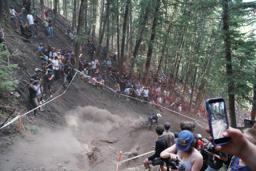 Spectators watch bikers navigate through the dust.