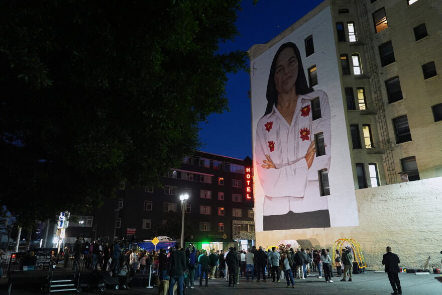 People gather a mural of Dolores Huerta by artist Robert Vargas, during a vigil to honor the labor organizer, whose advocacy improved conditions for migrant farm workers, Wednesday, Oct. 28, 2026, in Los Angeles.