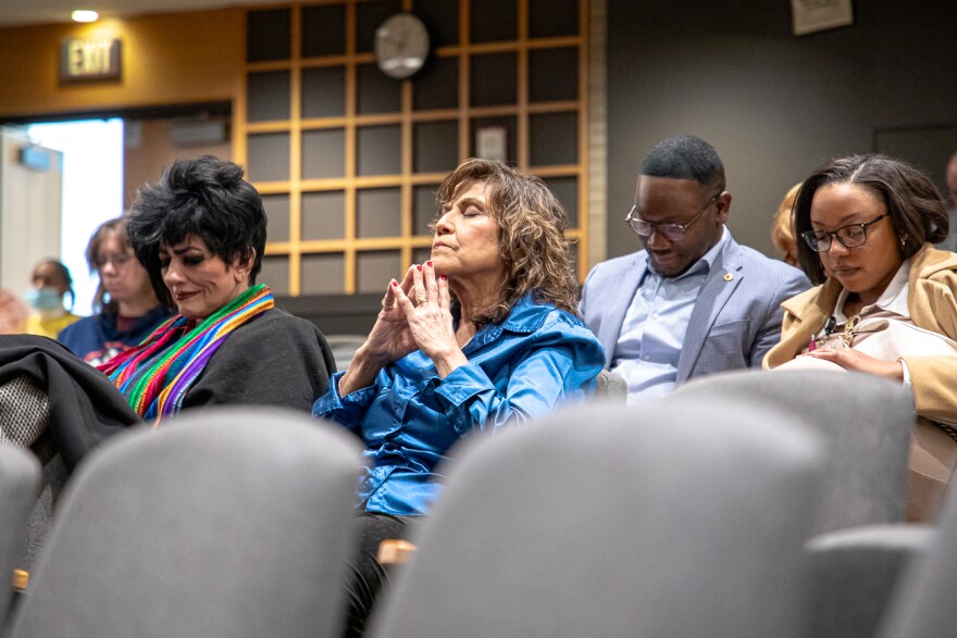 A member of the audience prays for the lives lost on flight 5342 on Jan. 29.