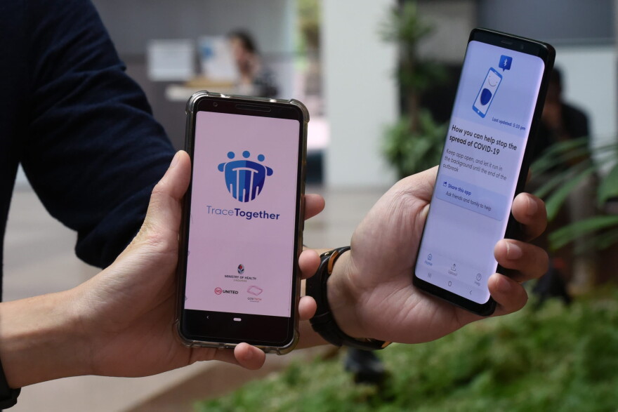 Government Technology Agency (GovTech) staff demonstrate Singapore's new contact-tracing smarthphone app called TraceTogether, as a preventive measure against the COVID-19 coronavirus in Singapore on March 20, 2020. (CATHERINE LAI/AFP via Getty Images)