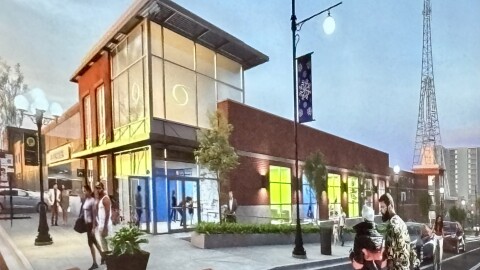 An artist rendering illustrates a corner building, with glass entrance doors, attached to a bus transfer center with a brick facade. Landscaped sidewalks line the outside of the building and casually-dressed people cross the intersection, arm in arm.