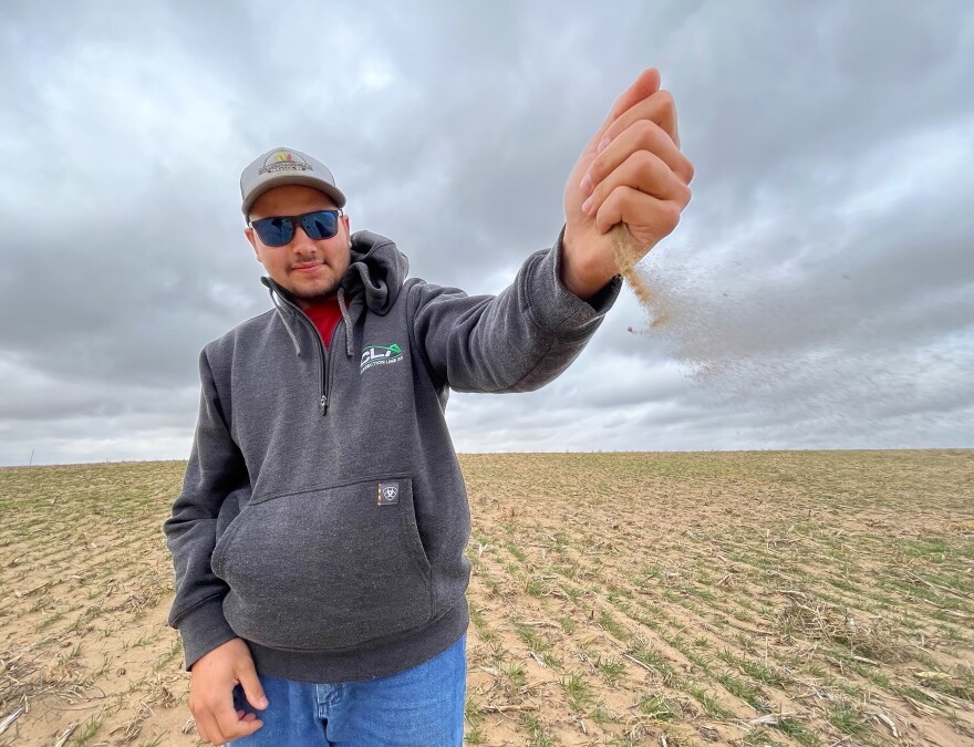 Man holding handful of dry dirt