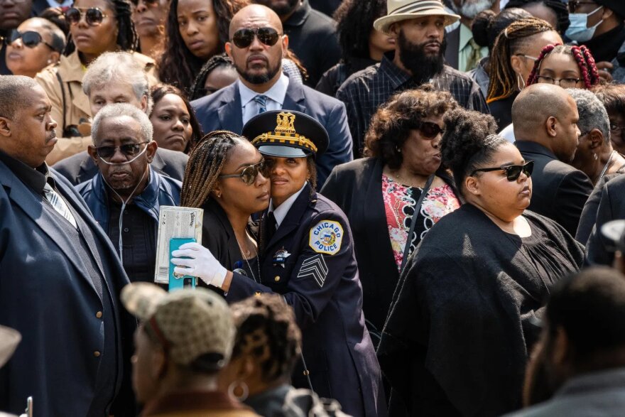 A police officer hugs Dionne Mhoon, mother of Officer Aréanah Preston, as Officer Preston’s hearse arrives before Preston’s funeral outside Trinity United Church of Christ in the Roseland neighborhood,