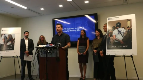 Harvard data scientist Kyle Frankovich stands at a Sept. 17, 2026, news conference between photos of Department of Homeland Security social media posts using images of him with his arms zip-tied behind his back after protesting at the Broadview immigration detention center.