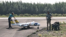 Brian Lu, left and Matt Westhoff check over the SeaHunter drone aircraft after a test flight at the Nenana Airport in July.